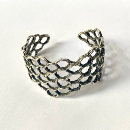 Bracelet ouvert avec son motif en forme de ruche.